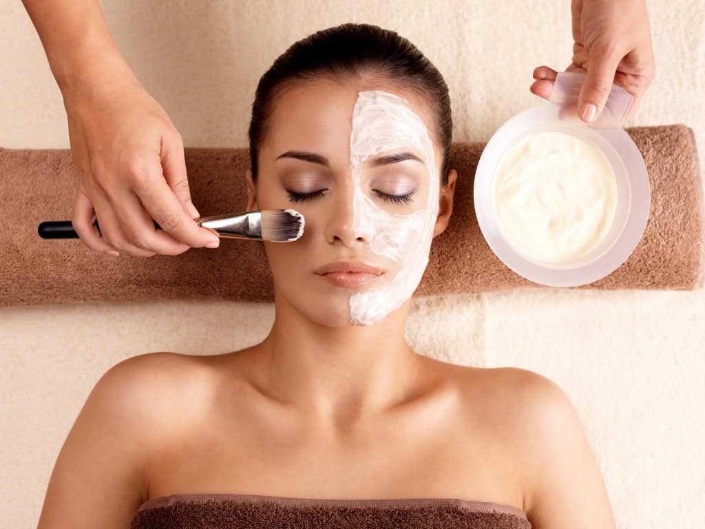 A woman, relaxed, receiving a beauty treatment
